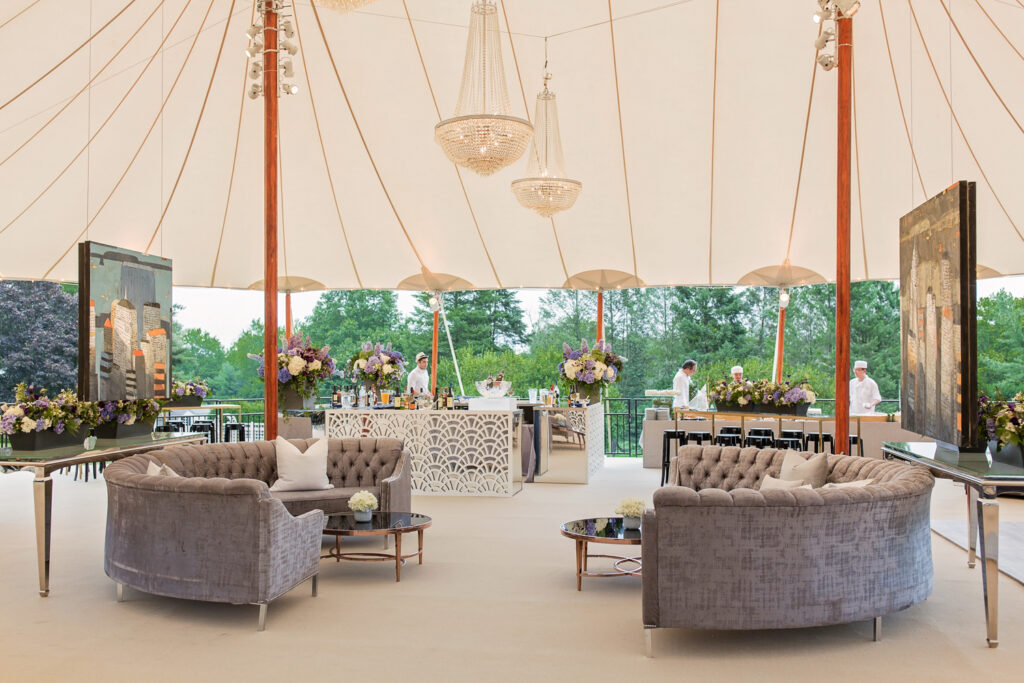 Wedding venue tent set up ready for the reception, with couches and artwork for guests to enjoy.