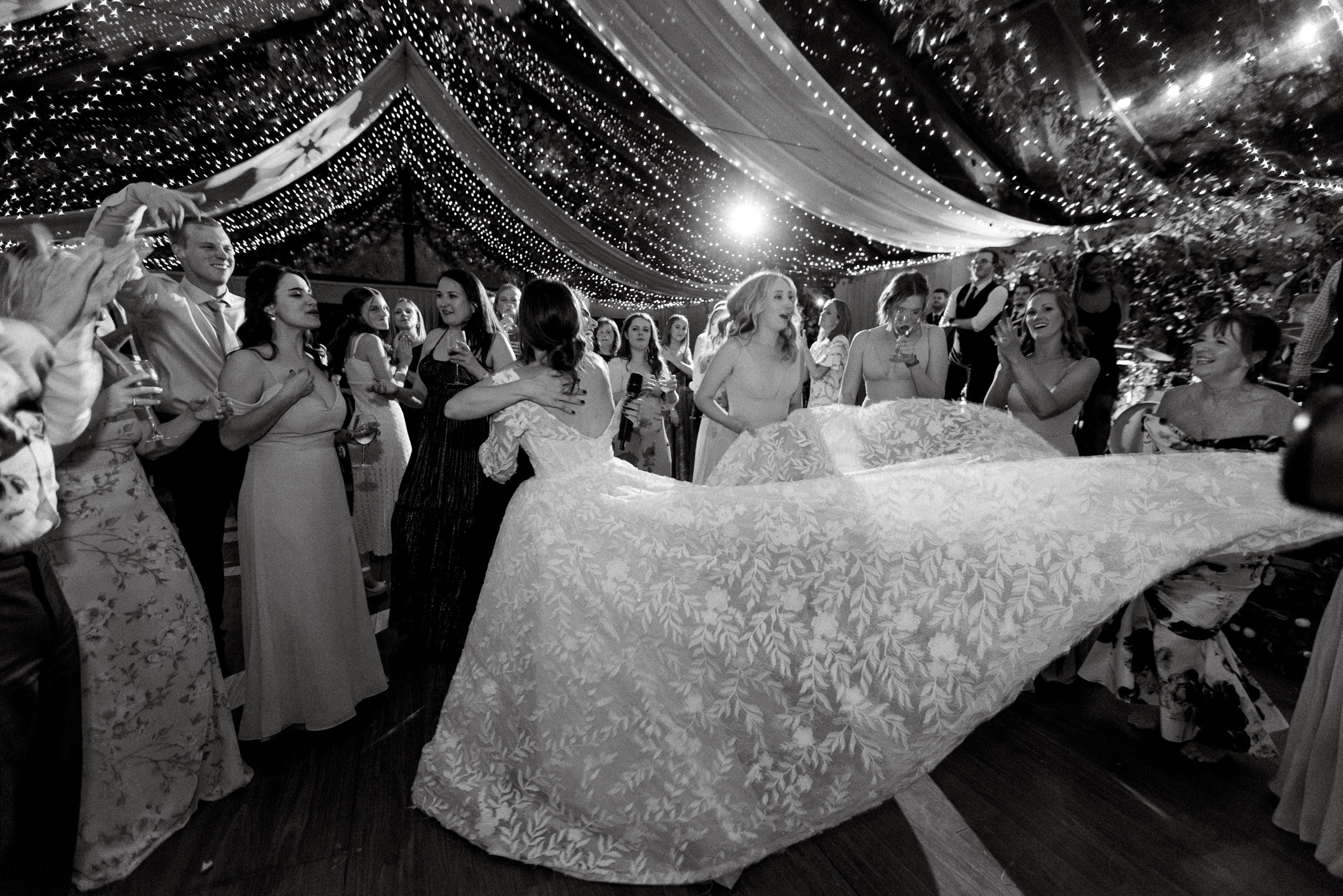 Guests and memebrs of the wedding party surround and embrace the bride during a lively nighttime reception under a clear tent strung with lights. best wedding photographers in Connecticut
best wedding photographers in New York city
best wedding photographers in tri-state area
Connecticut wedding photographer
Connecticut wedding planning
getaway wedding photographer
Litchfield county wedding photographer
Manhattan wedding planning
New York wedding photographer
travel wedding photographer
wedding day schedule
wedding day schedule template
wedding day timeline
wedding planning tips
wedding schedule template
when to start getting ready on my wedding day