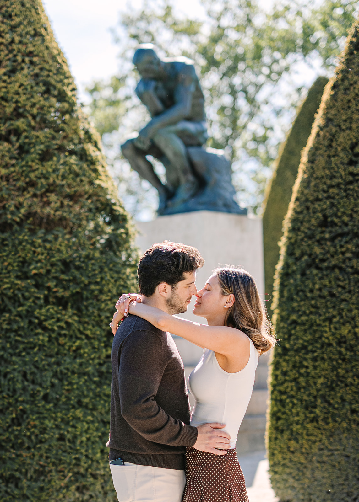 Newly Engaged Couple Embraces in Musée Rodin Near Sculpture The Thinker