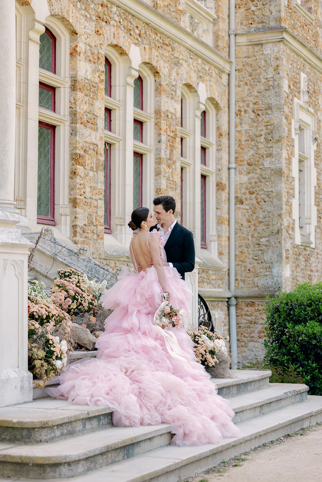 bride and broom on stone stairway of Château de Méridon for wedding