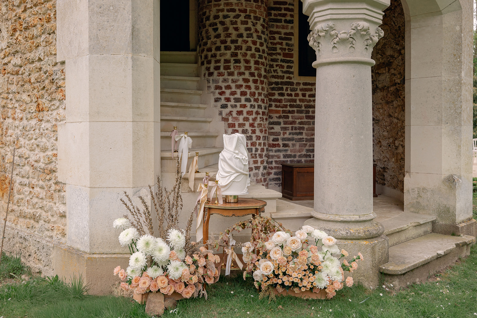 structurally designed wedding cake setup with peach and white flowers