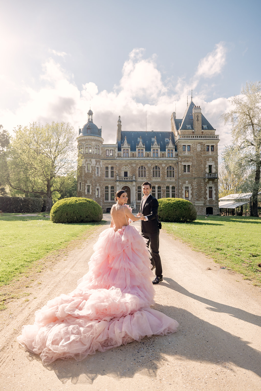 Bride and Groom Holding Hands Walking up Entryway to French Countryside Chateau