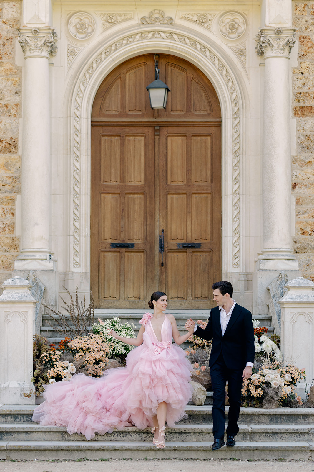 bride and groom ascend stairway at chateau near Paris for wedding