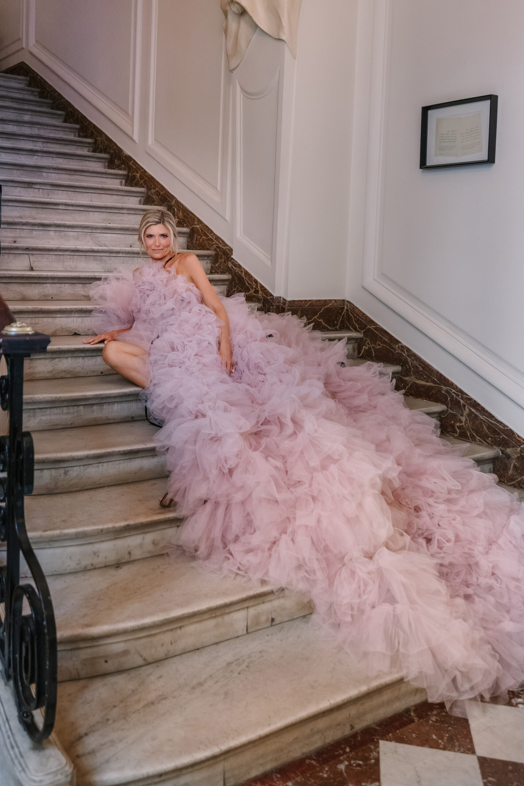 Stylish Bride to be Wearing Pink Tulle Gown with Cathedral Length train on Stairs of Parisian Hotel, staircase in paris
