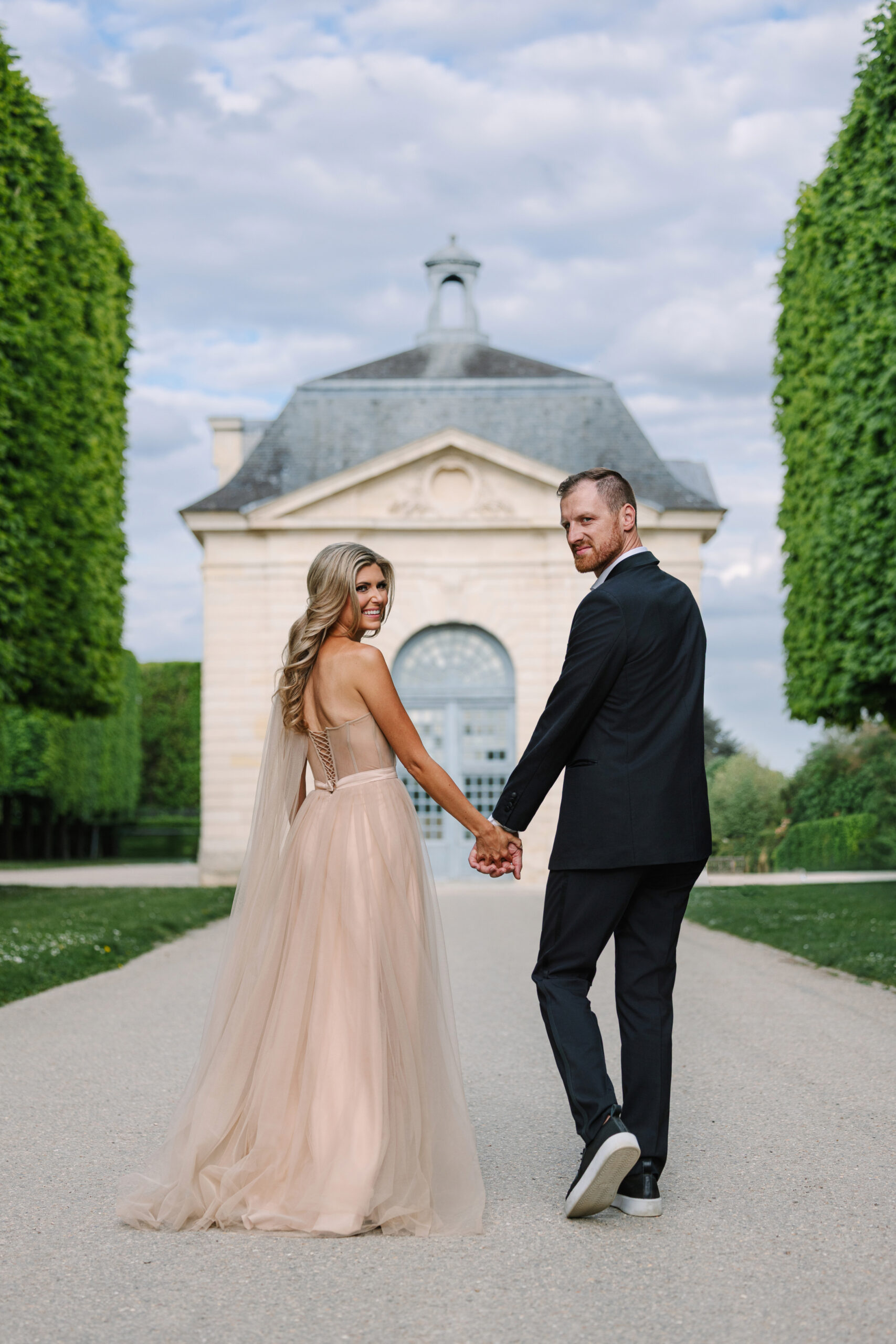 Couple Walk Through Gardens at Château de Sceaux for Paris Engagement Photos