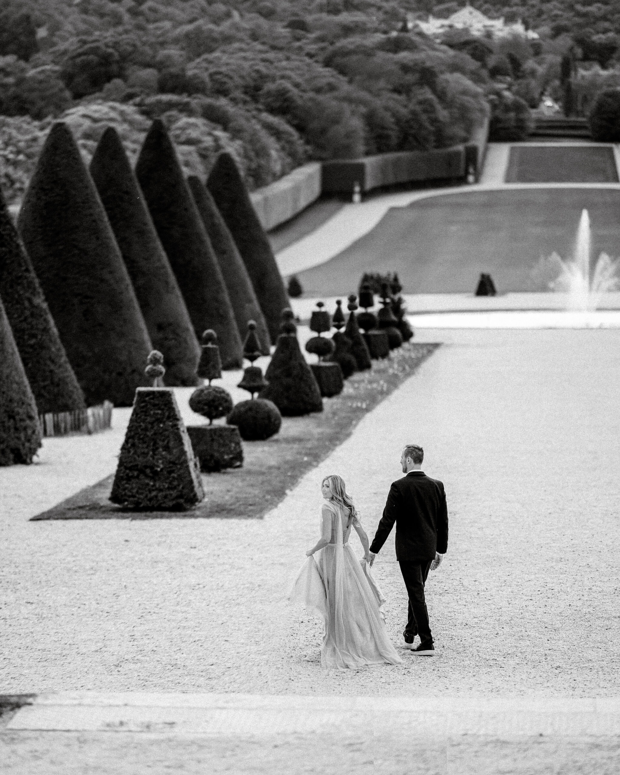 Dramatic Photo of Engaged Couple Walking Through Parisian Garden
